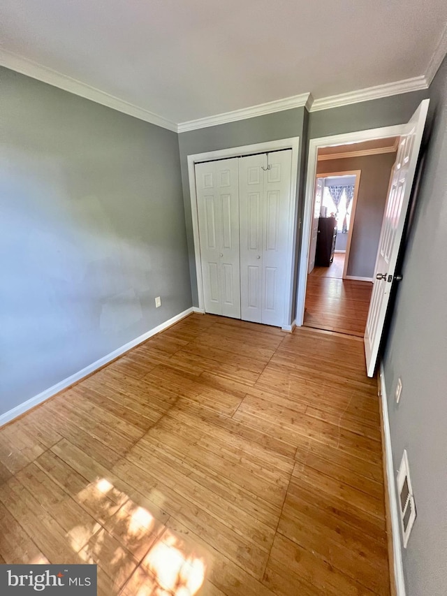 9837 Buckner Rd, Manassas, VA 20110 - unfurnished bedroom featuring light wood-type flooring, crown molding, and a closet