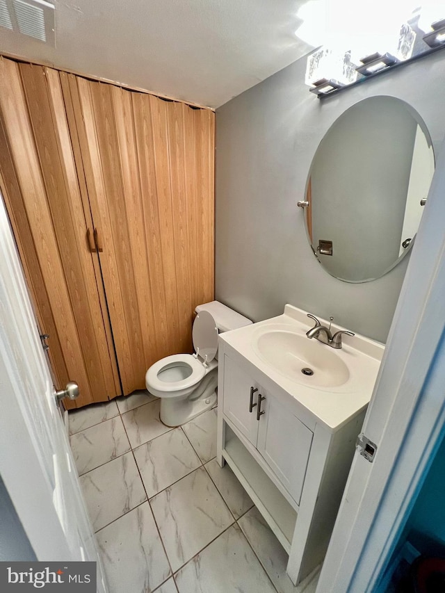 9837 Buckner Rd, Manassas, VA 20110 - half bathroom with marble finish flooring, vanity, and wooden walls