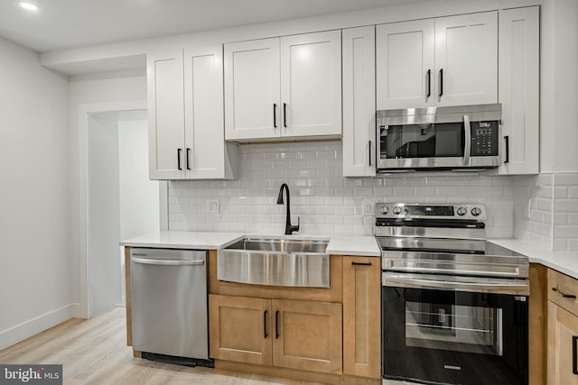 221 Ford St, Conshohocken, PA 19428 - kitchen with appliances with stainless steel finishes, decorative backsplash, light countertops, light wood-style floors, and recessed lighting