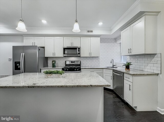 3922 Woodridge Rd, Baltimore, MD 21229 - kitchen with appliances with stainless steel finishes, decorative backsplash, a center island, crown molding, and white cabinetry