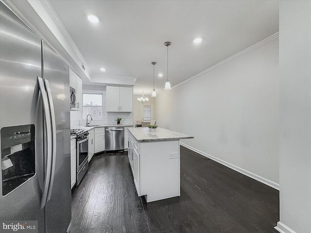 3922 Woodridge Rd, Baltimore, MD 21229 - kitchen featuring appliances with stainless steel finishes, ornamental molding, tasteful backsplash, a kitchen island, and dark wood finished floors