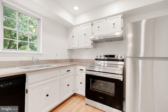 1951 Flowering Tree Ter, Silver Spring, MD 20902 - kitchen with stainless steel appliances, under cabinet range hood, white cabinets, light wood finished floors, and recessed lighting