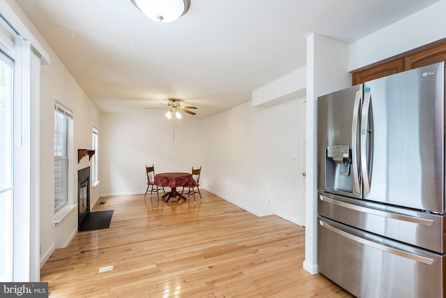 18432 Gardenia Way, Gaithersburg, MD 20879 - kitchen with stainless steel fridge with ice dispenser, ceiling fan, light wood-style floors, and a fireplace with flush hearth