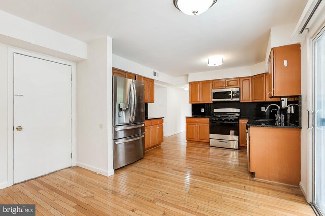18432 Gardenia Way, Gaithersburg, MD 20879 - kitchen with appliances with stainless steel finishes, brown cabinetry, light wood finished floors, and decorative backsplash