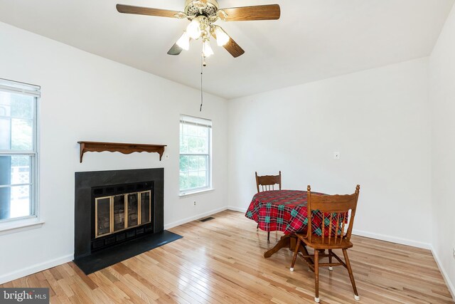 18432 Gardenia Way, Gaithersburg, MD 20879 - dining room featuring wood finished floors, a fireplace with flush hearth, and a ceiling fan