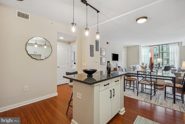 475 K St NW Unit 522, Washington, DC 20001 - kitchen with open floor plan, a kitchen breakfast bar, dark wood-type flooring, and dark countertops
