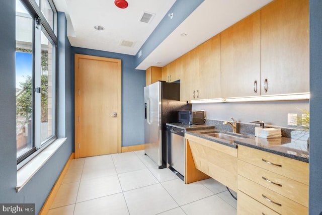 475 K St NW Unit 522, Washington, DC 20001 - kitchen with appliances with stainless steel finishes, dark stone countertops, light brown cabinetry, and light tile patterned floors