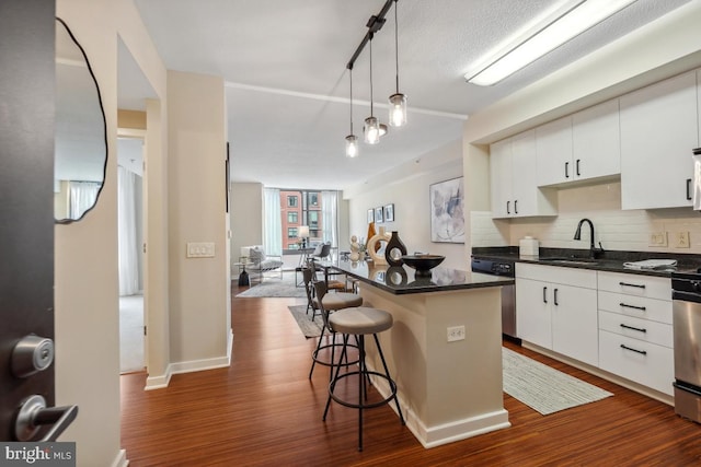 475 K St NW Unit 522, Washington, DC 20001 - kitchen with stainless steel dishwasher, dark countertops, a breakfast bar area, and backsplash