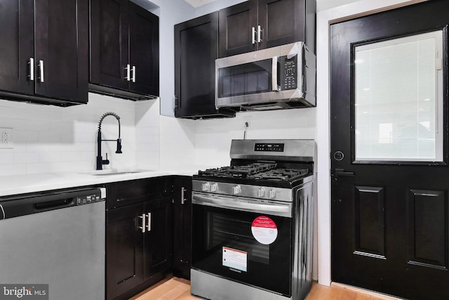 3914 Brandywine St, Philadelphia, PA 19104 - kitchen featuring appliances with stainless steel finishes, backsplash, light countertops, and light wood-style flooring