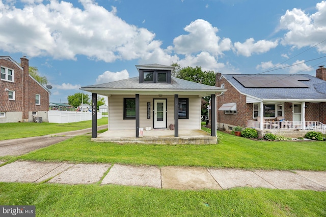 1065 Broadway Blvd, Reading, PA 19607 - bungalow-style home featuring a porch, roof mounted solar panels, and a shingled roof