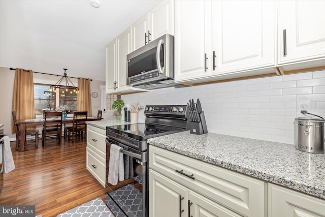 2 Forest Trl, Fairfield, PA 17320 - kitchen featuring black / electric stove, stainless steel microwave, decorative backsplash, white cabinetry, and wood finished floors