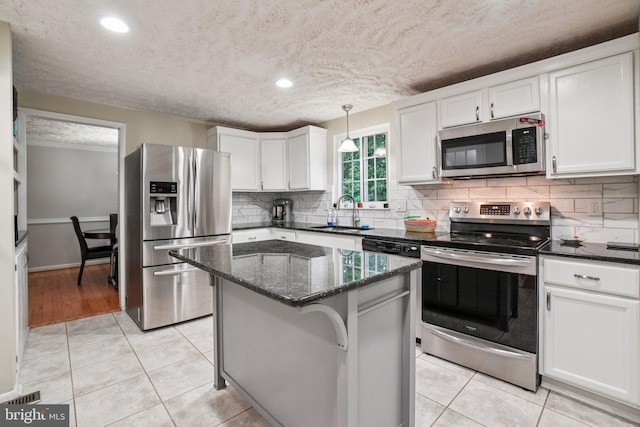 16041 Macedonia Dr, Woodbridge, VA 22191 - kitchen with stainless steel appliances, white cabinets, a textured ceiling, tasteful backsplash, and dark stone countertops
