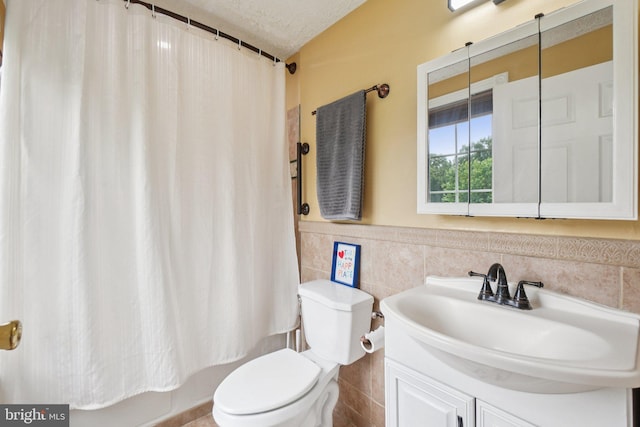16041 Macedonia Dr, Woodbridge, VA 22191 - bathroom with vanity, tile walls, a wainscoted wall, shower / bath combo, and a textured ceiling