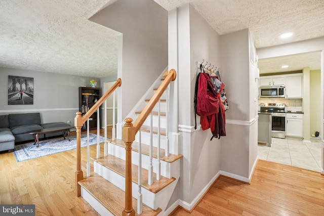 16041 Macedonia Dr, Woodbridge, VA 22191 - stairs with a textured ceiling and wood finished floors