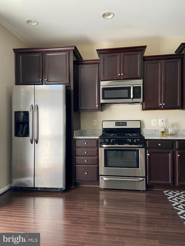 8930 Shadia Pl, Manassas, VA 20110 - kitchen with stainless steel appliances, dark brown cabinets, light stone counters, dark wood-type flooring, and recessed lighting