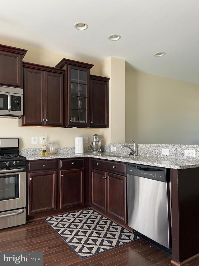 8930 Shadia Pl, Manassas, VA 20110 - kitchen featuring appliances with stainless steel finishes, dark wood-type flooring, dark brown cabinets, a peninsula, and glass insert cabinets