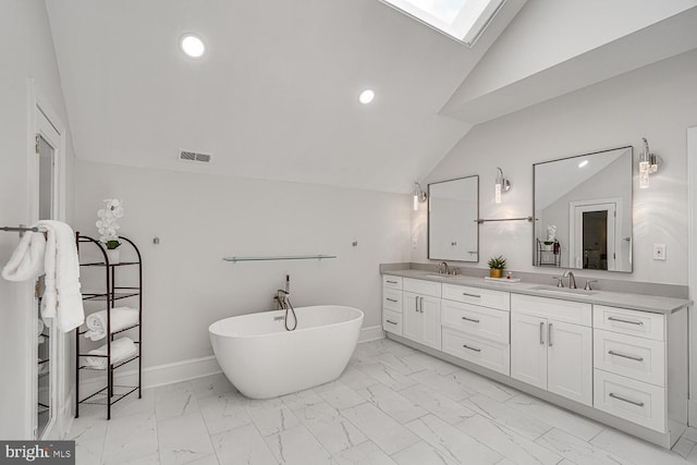 9118 Bells Mill Rd, Potomac, MD 20854 - full bath with vaulted ceiling, marble look tiles, double vanity, a freestanding bath, and a skylight