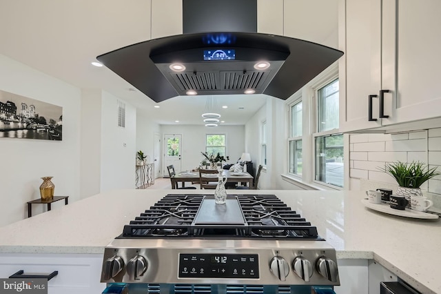 3814 Cedardale Rd, Baltimore, MD 21215 - kitchen with ventilation hood, stainless steel range with gas stovetop, white cabinetry, decorative backsplash, and recessed lighting