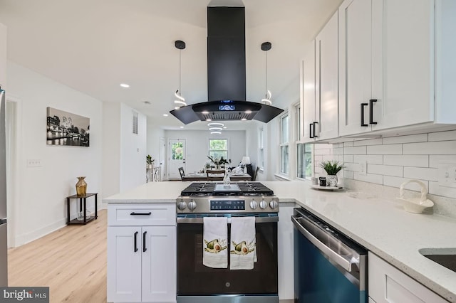 3814 Cedardale Rd, Baltimore, MD 21215 - kitchen featuring appliances with stainless steel finishes, island range hood, a peninsula, white cabinetry, and tasteful backsplash