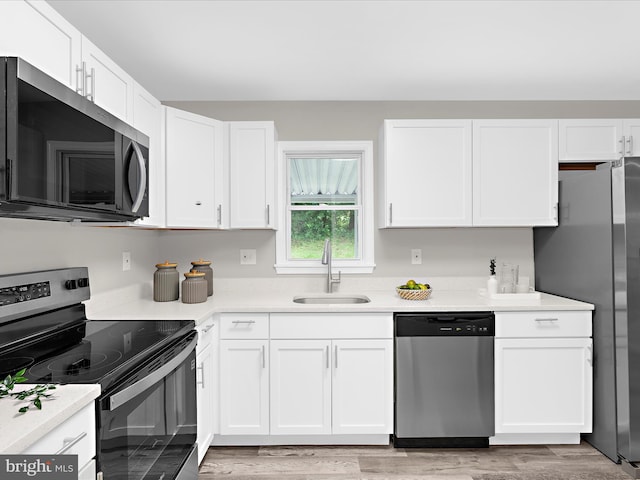 813 Ferguson Rd, Joppa, MD 21085 - kitchen featuring appliances with stainless steel finishes, white cabinets, light countertops, and light wood finished floors