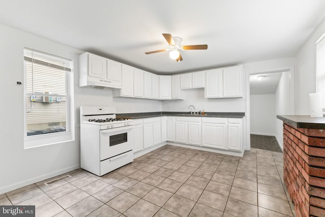 211 Broad St, Beverly, NJ 08010 - kitchen with white gas range oven, under cabinet range hood, ceiling fan, and healthy amount of natural light