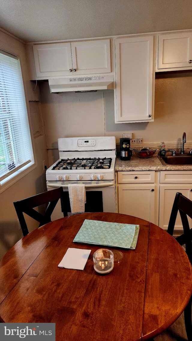 1025 Fredonia Ct, Baltimore, MD 21227 - kitchen featuring white range with gas stovetop, under cabinet range hood, and white cabinets