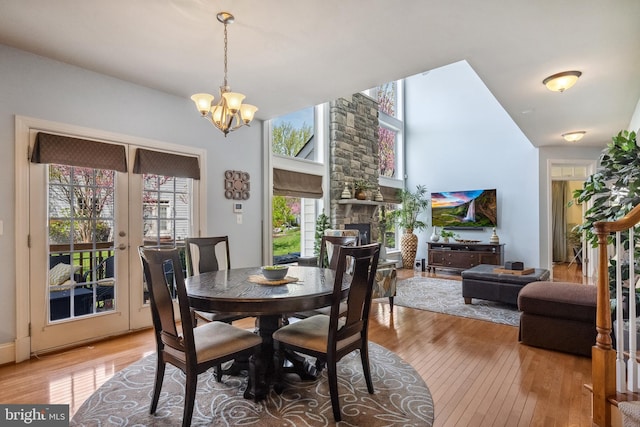 3716 Taft Ave, Alexandria, VA 22304 - dining space featuring a stone fireplace, light wood-style flooring, a chandelier, and french doors