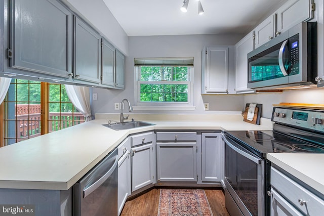 1651 Hugo Cir, Silver Spring, MD 20906 - kitchen with appliances with stainless steel finishes, dark wood-type flooring, light countertops, and a peninsula
