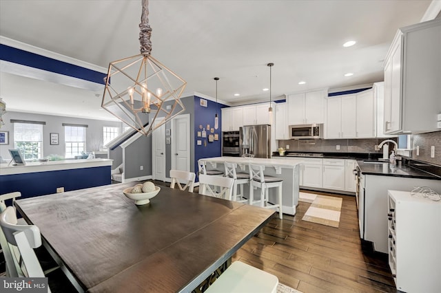 2596 Twin Birch Rd, Hanover, MD 21076 - dining space with a chandelier, dark wood finished floors, crown molding, stairs, and recessed lighting