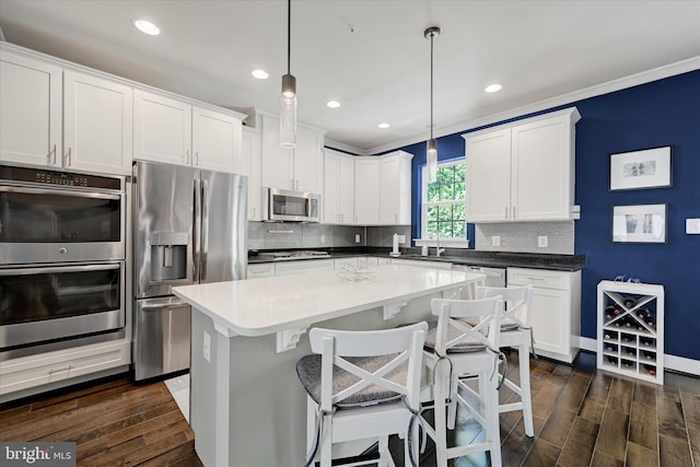 2596 Twin Birch Rd, Hanover, MD 21076 - kitchen with stainless steel appliances, dark wood-style floors, decorative backsplash, white cabinetry, and recessed lighting