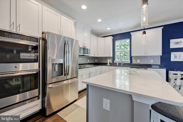2596 Twin Birch Rd, Hanover, MD 21076 - kitchen with appliances with stainless steel finishes, wood finished floors, a breakfast bar, decorative backsplash, and recessed lighting