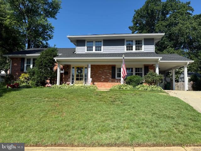 301 Mcdonough Rd, Annapolis, MD 21401 - traditional-style house featuring a front lawn, driveway, a carport, and brick siding