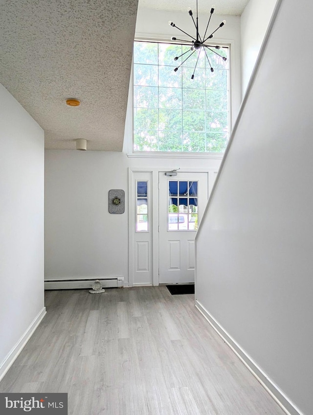532 Sunrise Ave, Harbour View, Somers Point, NJ 08244 - entrance foyer featuring a chandelier, a baseboard heating unit, wood finished floors, plenty of natural light, and a textured ceiling