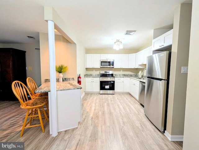 532 Sunrise Ave, Harbour View, Somers Point, NJ 08244 - kitchen featuring stainless steel appliances, light stone counters, light wood-style floors, and white cabinets