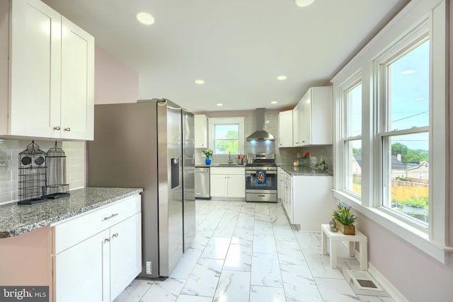 2721 Louise Ave, Baltimore, MD 21214 - kitchen with appliances with stainless steel finishes, wall chimney exhaust hood, light marble finish floors, white cabinetry, and recessed lighting