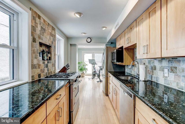 307 S Exeter St, Baltimore, MD 21202 - kitchen with appliances with stainless steel finishes, tasteful backsplash, light wood-style flooring, dark stone counters, and light brown cabinets