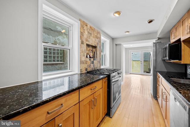 307 S Exeter St, Baltimore, MD 21202 - kitchen with stainless steel appliances, light wood-style floors, dark stone countertops, and backsplash