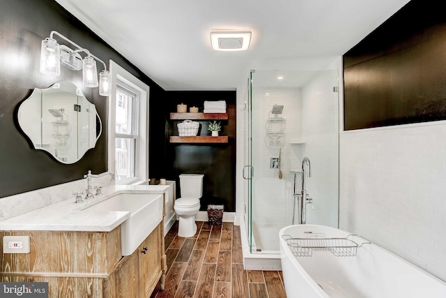 307 S Exeter St, Baltimore, MD 21202 - bathroom featuring vanity, a stall shower, a soaking tub, and wood finish floors