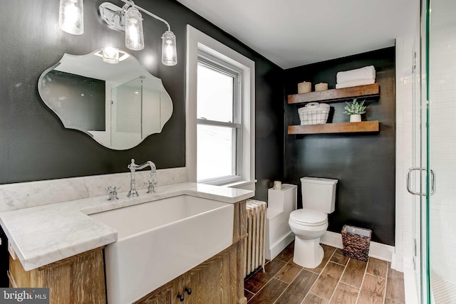 307 S Exeter St, Baltimore, MD 21202 - full bathroom with a stall shower, vanity, wood tiled floors, and radiator