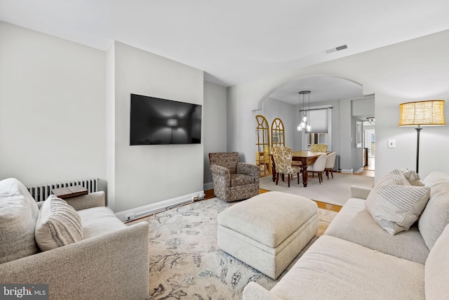 307 S Exeter St, Baltimore, MD 21202 - living area with arched walkways, radiator, and a chandelier