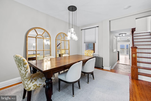 307 S Exeter St, Baltimore, MD 21202 - dining area featuring stairway, radiator heating unit, and wood finished floors