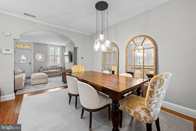 307 S Exeter St, Baltimore, MD 21202 - dining space with arched walkways, wood finished floors, and ornamental molding