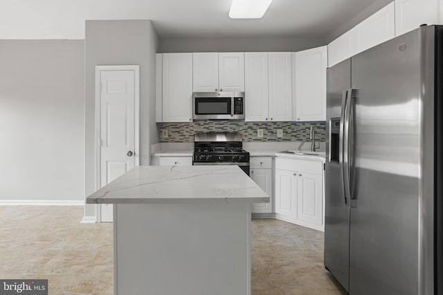 21024 Mossy Glen Ter, Ashburn, VA 20147 - kitchen featuring appliances with stainless steel finishes, white cabinetry, light stone countertops, decorative backsplash, and a kitchen island
