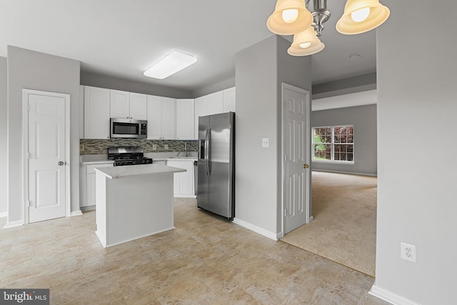 21024 Mossy Glen Ter, Ashburn, VA 20147 - kitchen featuring stainless steel appliances, light countertops, white cabinetry, a kitchen island, and tasteful backsplash