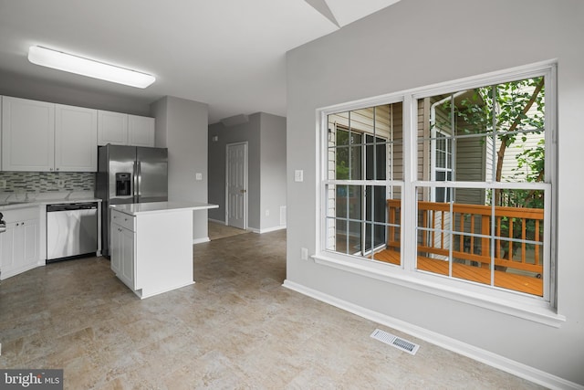 21024 Mossy Glen Ter, Ashburn, VA 20147 - kitchen with stainless steel appliances, light countertops, decorative backsplash, white cabinetry, and a center island