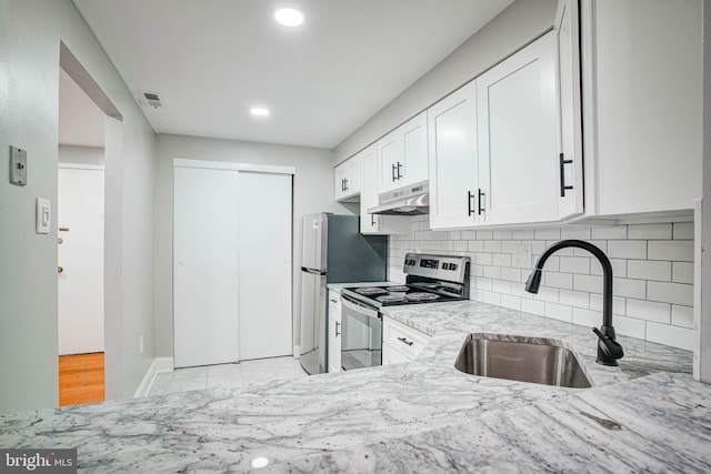 825 N 29th St Unit 1B, Philadelphia, PA 19130 - kitchen with stainless steel electric range, under cabinet range hood, light stone counters, white cabinets, and decorative backsplash