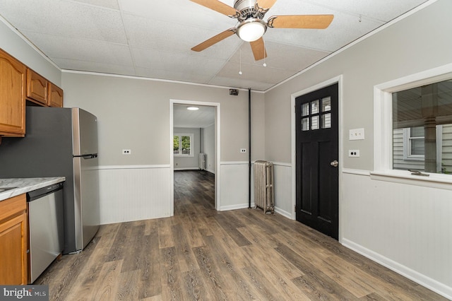 324 N 2nd St, Lykens, PA 17048 - kitchen featuring stainless steel appliances, a wainscoted wall, brown cabinets, dark wood-style floors, and a ceiling fan
