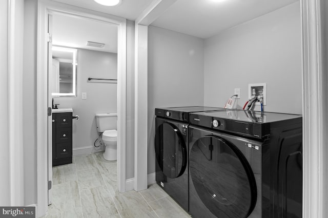 816 Carroll St, Baltimore, MD 21230 - laundry area featuring washer and dryer and light marble finish floors