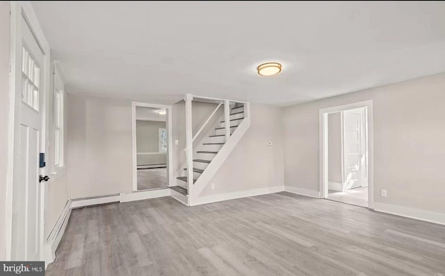 1832 E Buckshutem Rd, Millville, NJ 08332 - empty room with wood finished floors, stairs, a baseboard heating unit, and baseboard heating