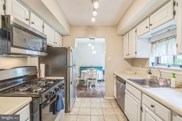 9001 Ridge Ave Unit 31, Philadelphia, PA 19128 - kitchen featuring stainless steel appliances, white cabinets, light countertops, and light tile patterned floors